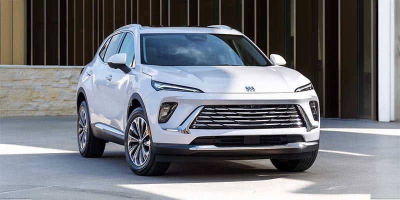 Front view of a 2025 Buick Envision in silver, parked outside a modern building