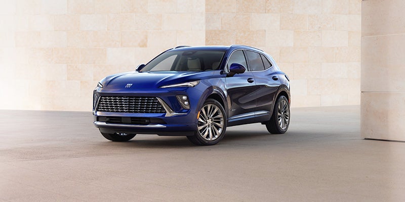 Blue Buick Envision parked near a cream stone wall representing remote command features